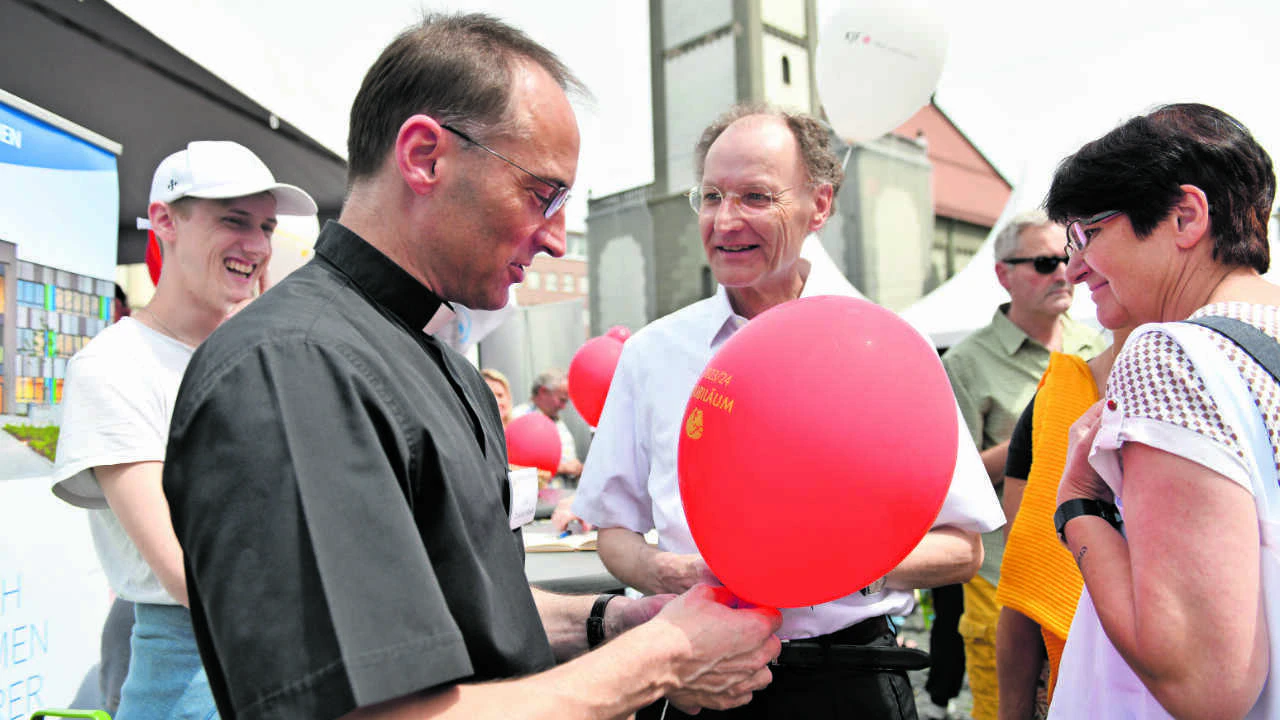 Beim großen Jubiläumsfest auf dem Augsburger Rathausplatz ließ auch Stadtpfarrer Christoph Hänsler (vorne) eine Wunschkarte per Luftballon zum Himmel steigen. In der Bildmitte: Generalvikar Monsignore Wolfgang Hacker. (Foto: Rösch/pba)