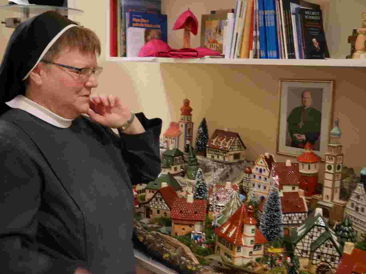 Schwester Dominika freut sich über das Keramikmodell des Augsburger Perlachturms (rechts), der das Lichterdorf von Bischof Bertram bereichert. Foto: Gerhard Buck