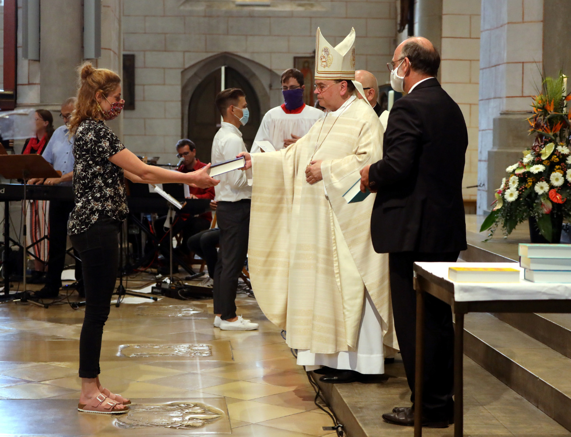 Bischof Bertram übergibt den Religionslehrern eine Bibel als Zeichen für ihren Dienst am Wort. Rechts: Oberstudiendirektor Bernhard Rößner. Foto: Zoepf