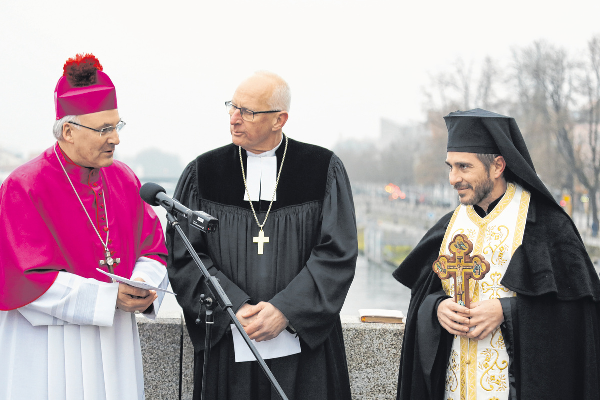 Bei der Segnungszeremonie auf der Steinernen Brücke (von links): Bischof Rudolf Voderholzer, Regionalbischof Klaus Stiegler und Archimandrit Petros Klitsch mit dem Segungskreuz. 