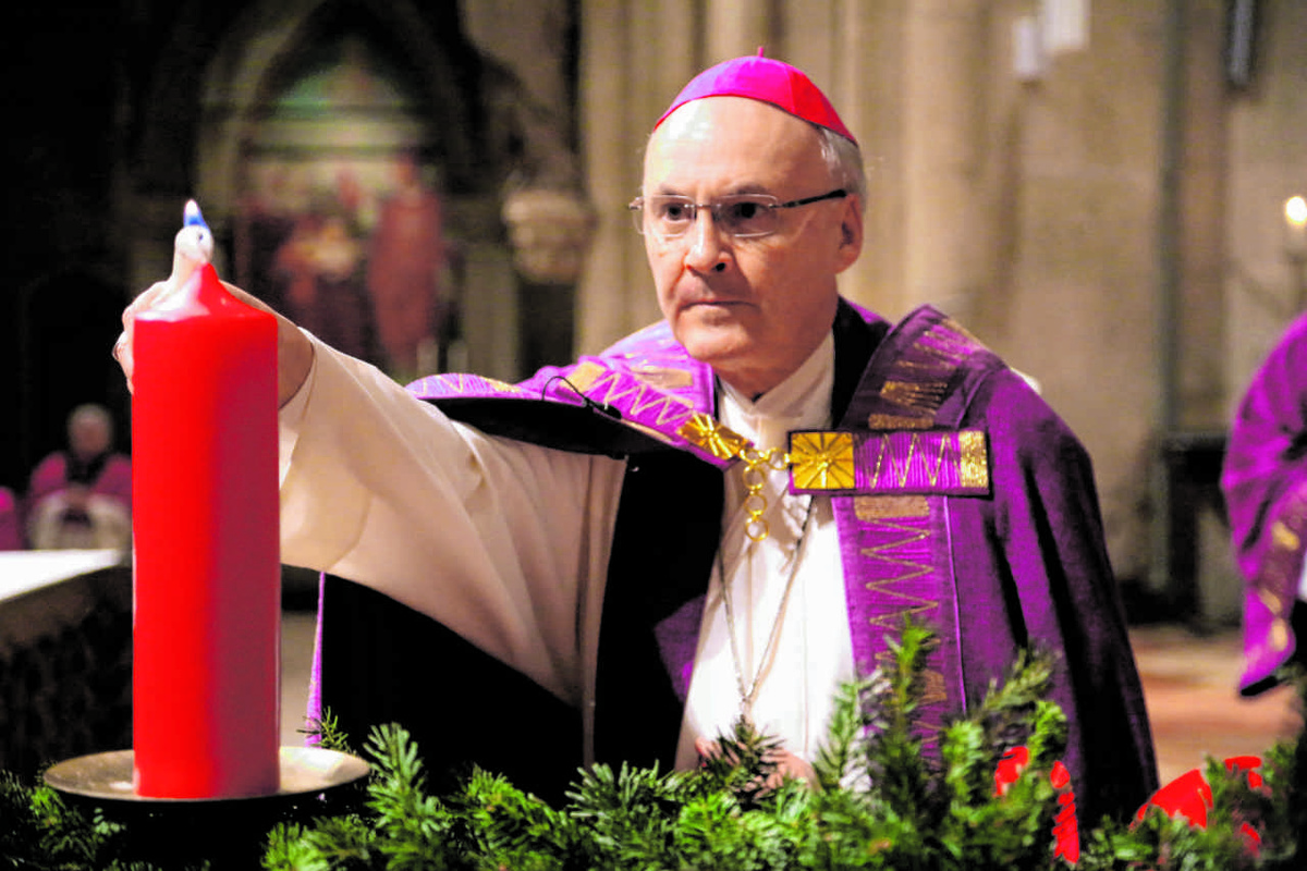 Bischof Rudolf Voderholzer entzündet am Adventskranz im Dom die erste Kerze.