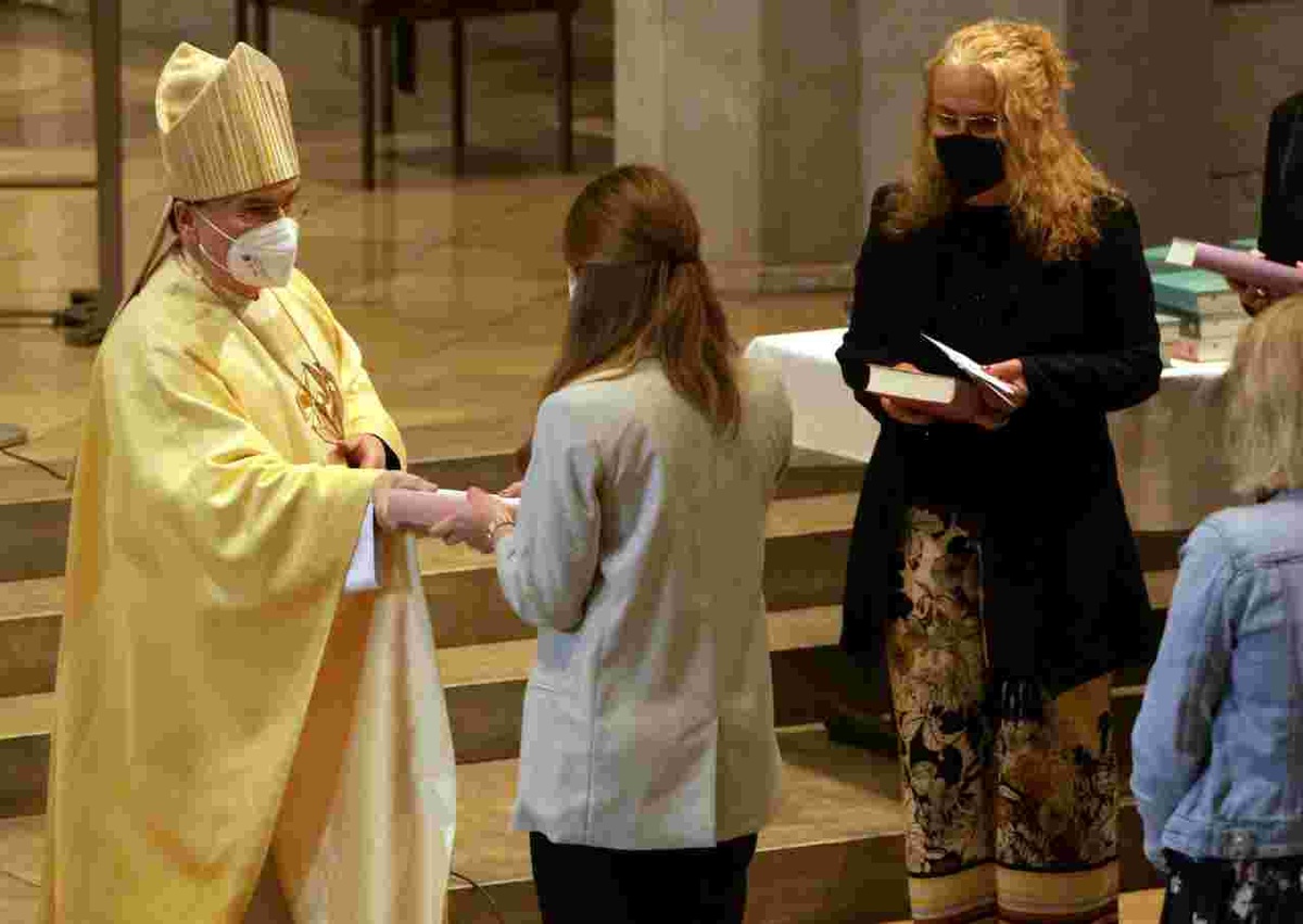 Bischof Bertram übergibt einer Religionslehrerin anlässlich der Verleihung der Missio Canonica die BibeL Foto: Annette Zoepf