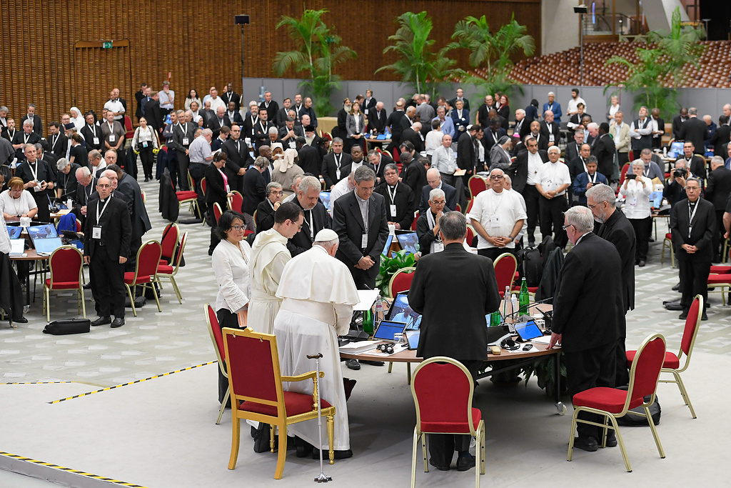 Teilnehmer stehen mit Papst Franziskus an Tischen bei den Beratungen während der Weltsynode am 25. Oktober 2023 im Vatikan. (Foto: KNA)