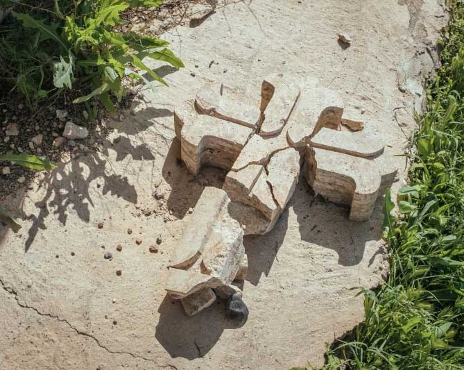 Ein zerstörtes Kreuz auf dem Gelände einer christlichen Kirche im Irak. Attentate auf das Christentum seien lediglich politisch-mediale Randnotizen, kritisiert der Kommentator. (Foto: KNA)