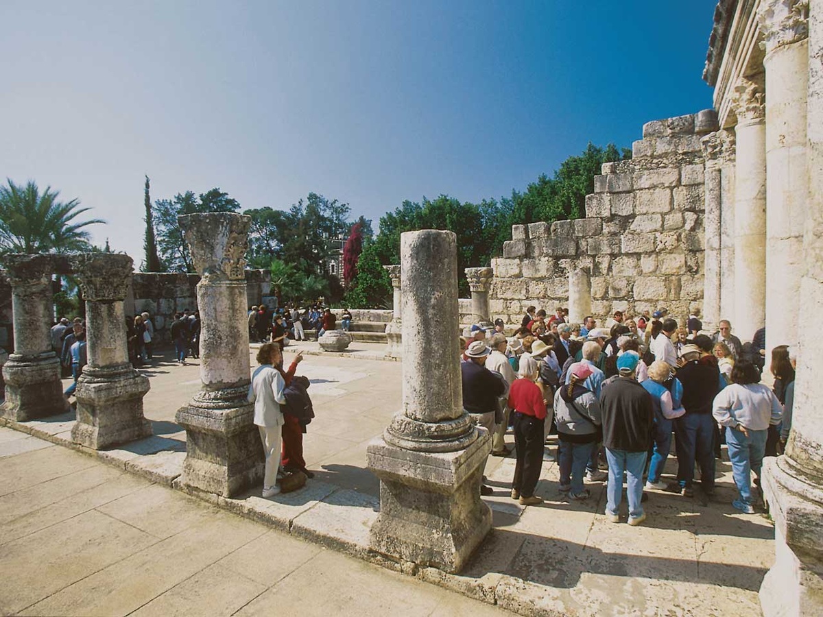 Touristen besichtigen die Ruinen der Synagoge von Kafarnaum. (Foto: KNA)