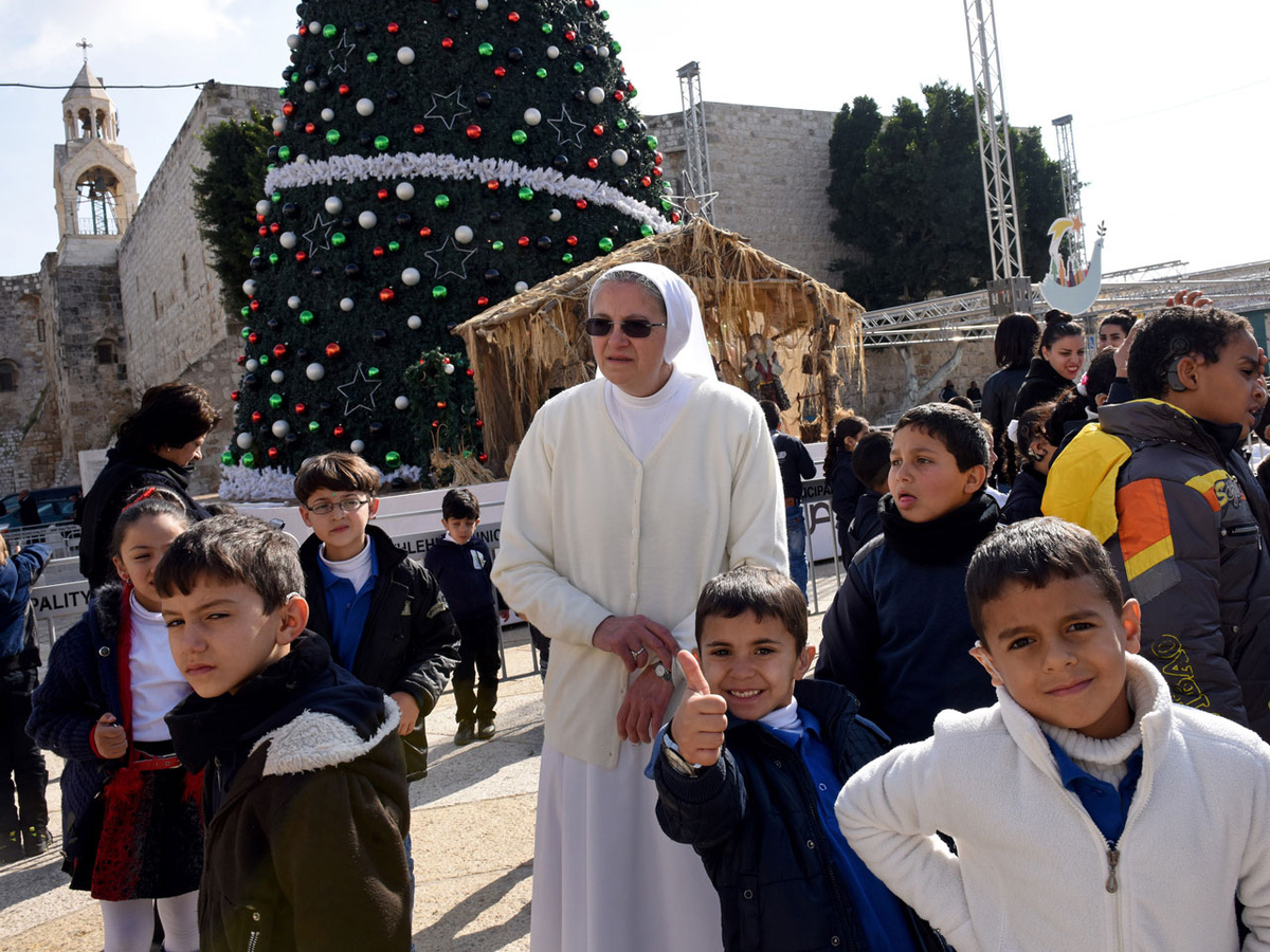 Diese palästinensischen Kinder, die mit einer Ordensschwester den Krippenplatz vor der Geburtskirche in Bethlehem besuchen, freuen sich auf Weihnachten. Doch von echtem Weihnachtsfrieden ist der Geburtsort Jesu weit entfernt. (Foto: KNA)