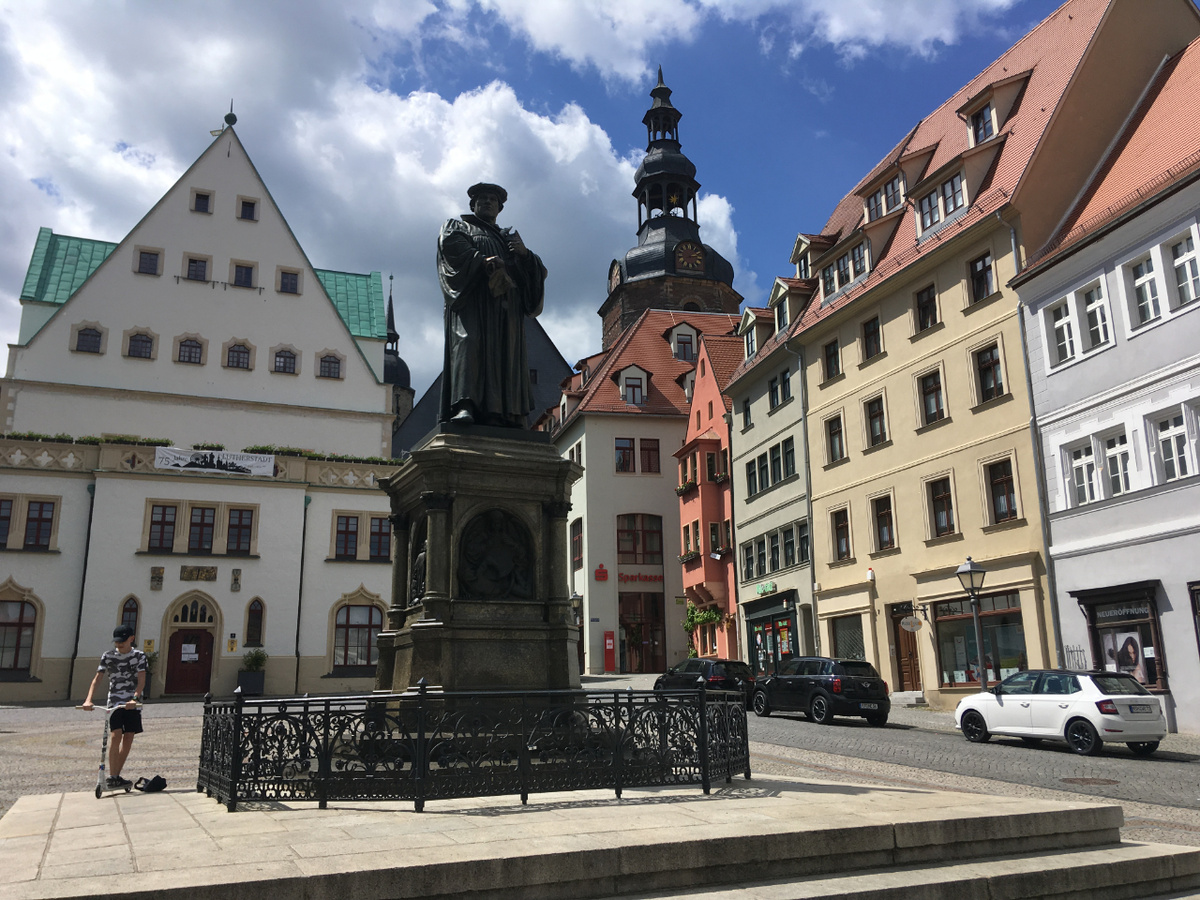 Das Lutherdenkmal auf dem Marktplatz von Eisleben. Im Hintergrund: das Rathaus (links) und die Türme der Andreaskirche. (Foto: Fels)