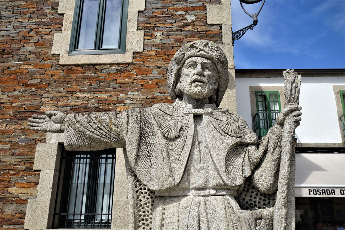 „Da geht’s lang“, weist die Jakobus­skulptur im galizischen Pilgerort Portomarin den Weg.  (Foto: Drouve)