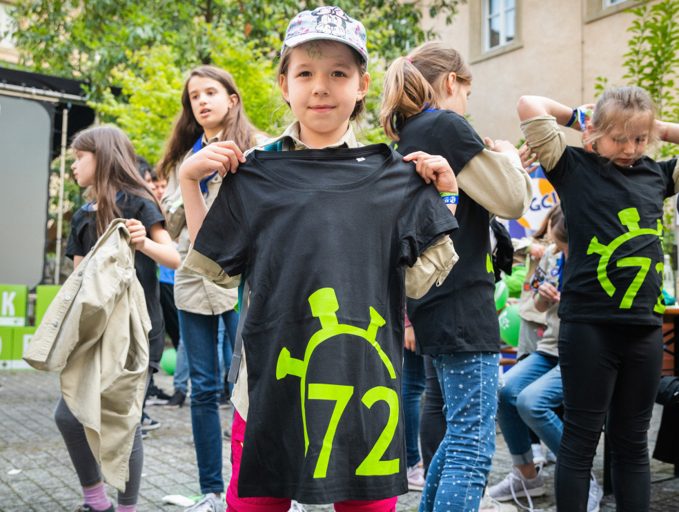 Ein Mädchen zeigt ein T-Shirt mit dem Aufdruck "72" während der Auftaktveranstaltung zur 72-Stunden-Aktion des BDKJ (Bund der Deutschen Katholischen Jugend) am 23. Mai 2019 in Würzburg.  (Foto: KNA)