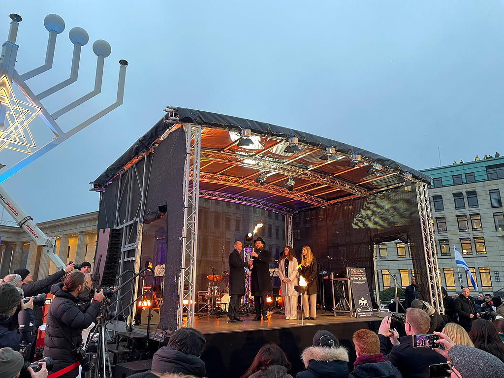 Bundeskanzler Olaf Scholz (Bühne links) bei der Entzündung des Chanukka-Leuchters am 7. Dezember 2023 vor dem Brandenburger Tor in Berlin. (Foto: KNA)
