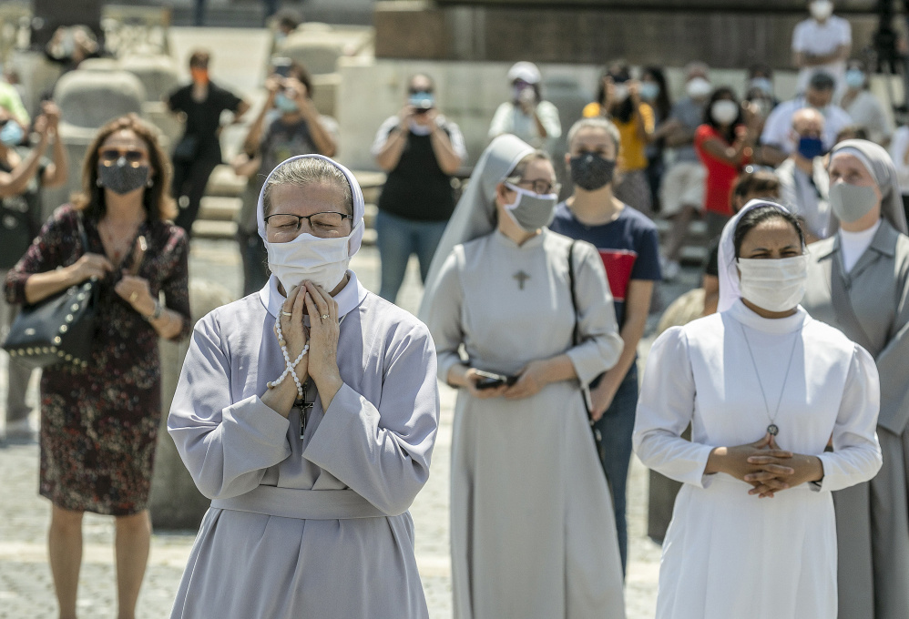 Gläubige, darunter Ordensfrauen, tragen Mundschutz und stehen mit Abstand zueinander auf dem wiedereröffneten Petersplatz während des Angelusgebets mit Papst Franziskus am 24. Mai 2020 im Vatikan. (Foto: KNA)