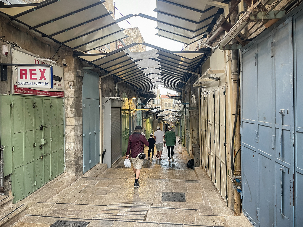 Nur wenige Menschen gehen am 7. Oktober 2023 durch eine leere Gasse, vorbei an geschlossenen Geschäften, in der Altstadt von Jerusalem (Israel). Das Sicherheitskabinett der israelischen Regierung billigte in der Nacht zum 8. Oktober die Ausrufung des Kriegszustands und die damit verbundene Einleitung militärischer Maßnahmen. (Foto: KNA)