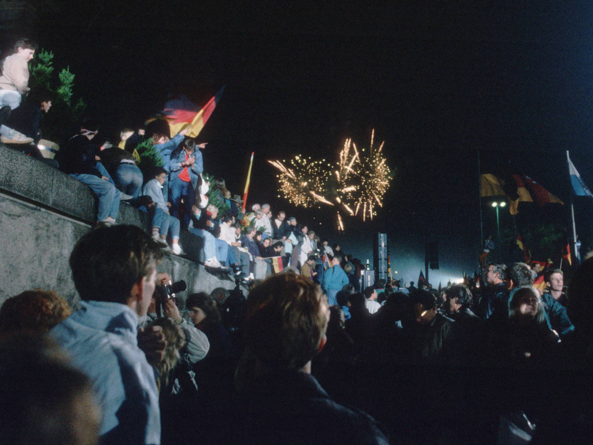 Die Mauer ist gefallen! Glückliche Menschen feiern am 9. November 1989 vor und auf der Berliner Mauer die Deutsche Wiedervereinigung. (Foto: imago/photothek)