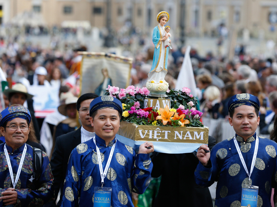Vietnamesische Katholiken tragen eine Marienfigur in einer Prozession zu Beginn einer Marienandacht auf dem Petersplatz im Oktober 2016 im Vatikan. (Foto: KNA)