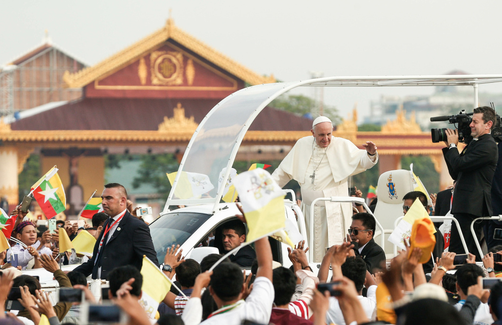 Papst Franziskus fährt mit dem Papamobil über das Kyaikkasan-Sportgelände in Rangun und begrüßt die Menschen am 29. November 2017. Menschen schwenken Fahnen von Myanmar und dem Vatikan. (Foto: KNA)