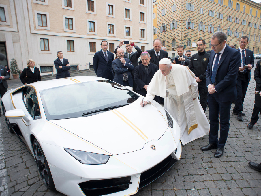 Papst Franziskus unterschreibt am 15. November 2017 auf einem weißen Lamborghini Huracan, den er geschenkt bekommen hat. (Foto: KNA)