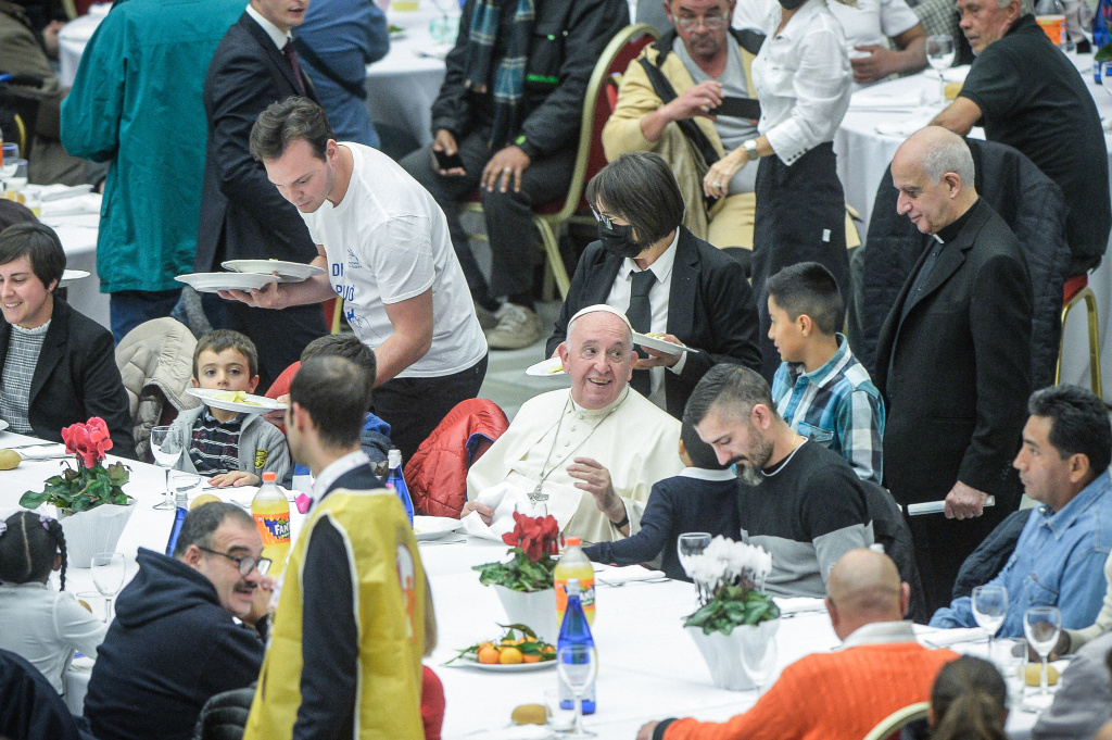Papst Franziskus sitzt an einem Tisch bei einem Mittagessen zum Welttag der Armen am 13. November 2022 in der Synodenaula im Vatikan. (Foto: KNA)