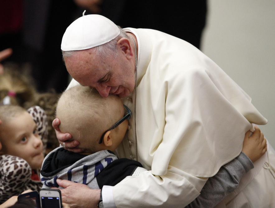 Papst Franziskus umarmt ein Kind während eines Treffens mit behinderten Menschen am 13. Januar 2016 im Vatikan. (Foto: KNA)
