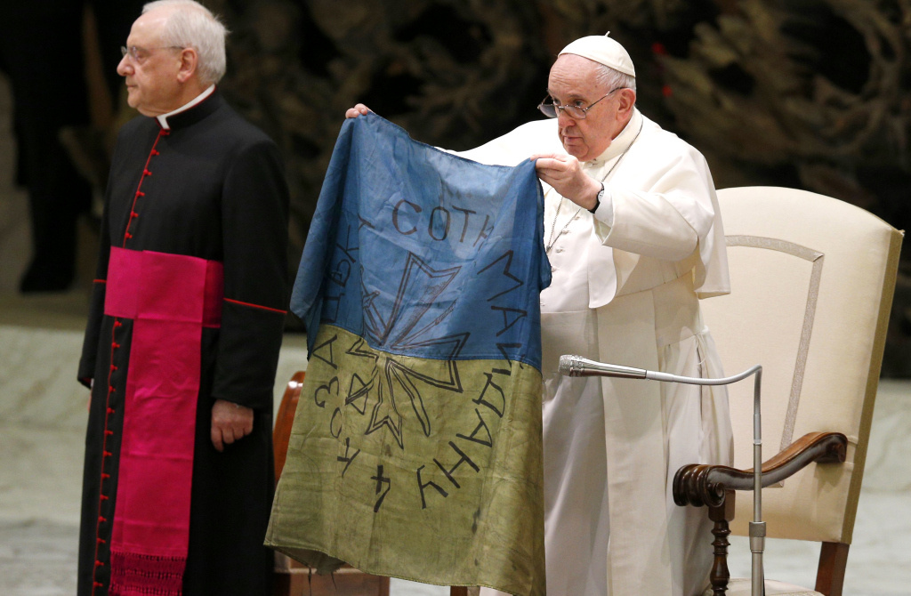 Papst Franziskus zeigt eine ukrainische Nationalflagge, die er aus dem ukrainischen Ort Bucha erhalten hat, während der Generalaudienz am 6. April 2022 im Vatikan. (Foto: KNA)