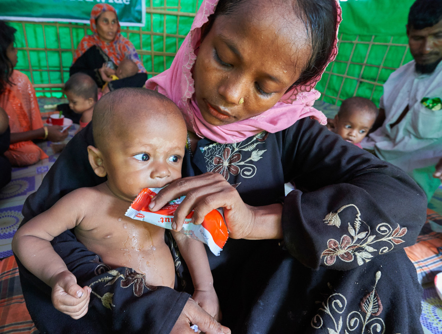 Eine Angehörige der Rohingya füttert ihr Kind im Flüchtlingslager Balukhali nahe Cox's Bazar (Bangladesch). (Foto: KNA)
