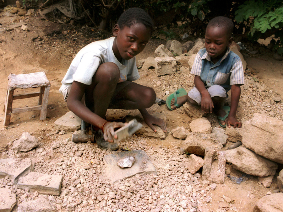 Kinder in der sambischen Hauptstadt Lusaka sitzen auf dem Boden und klopfen Steine. (Foto: KNA)