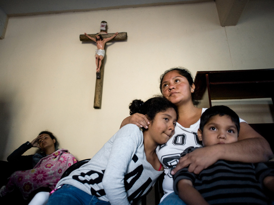 Eine Mutter hält im April 2018 in einer Flüchtlingsunterkunft der Caritas nahe der Grenze zu den USA in Tijuana ihre Kinder im Arm. (Foto: KNA)