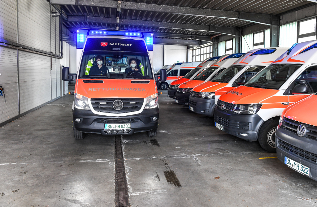 Ein Rettungswagen des Malteser Rettungsdienstes steht mit Blaulicht neben Krankenwagen in der Garage am Stützpunkt Bonn. (Foto: KNA)