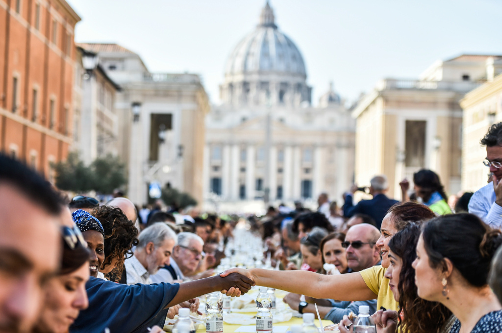 Viele Menschen essen gemeinsam an einer großen Tafel vor dem Petersdom unter dem Motto "Tavolata Romana Senza Muri" (Römischer Tisch ohne Mauern). (Foto: KNA)