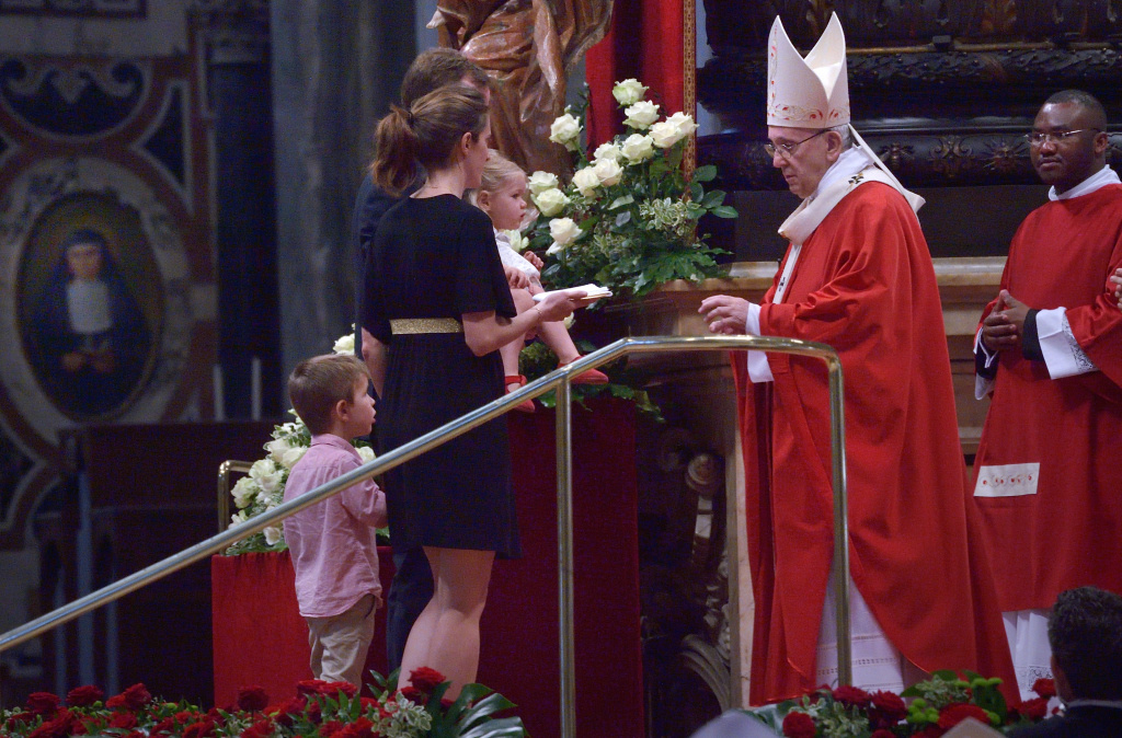 Eine Familie steht während der Pfingstmesse vor Papst Franziskus. (Foto: KNA)