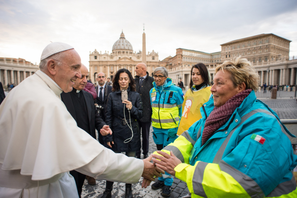 Papst Franziskus begrüßt eine Helferin während seines Überraschungsbesuchs bei einer mobilen medizinischen Notstation für Arme.    Foto: KNA