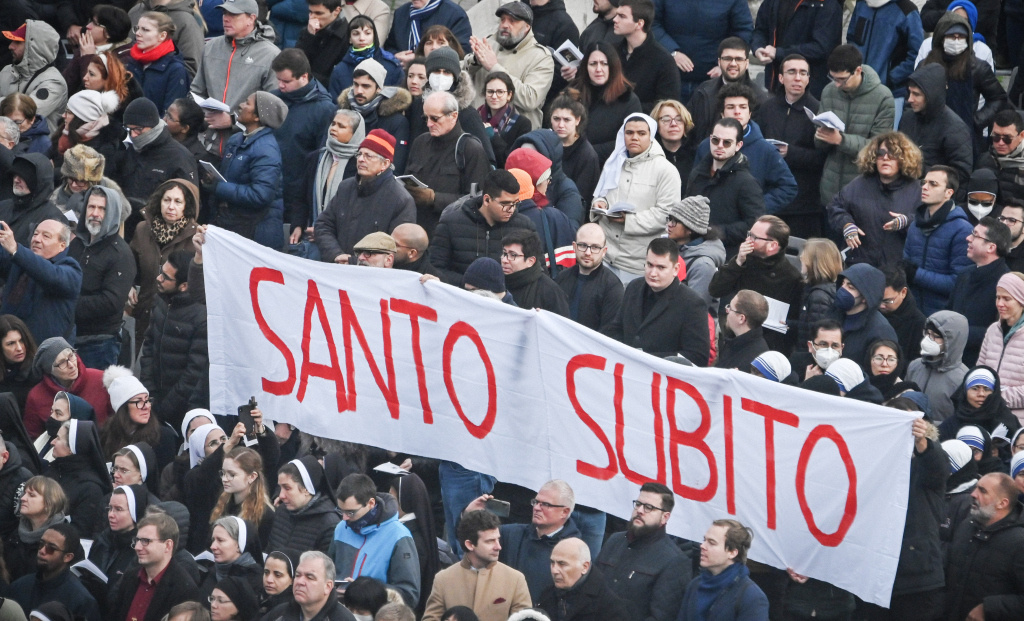 Teilnehmer halten während der Trauermesse für den emeritierten Papst Benedikt XVI. auf dem Petersplatz im Vatikan ein großes Banner mit der Aufschrift "Santo Subito" in die Höhe. (Foto: KNA)