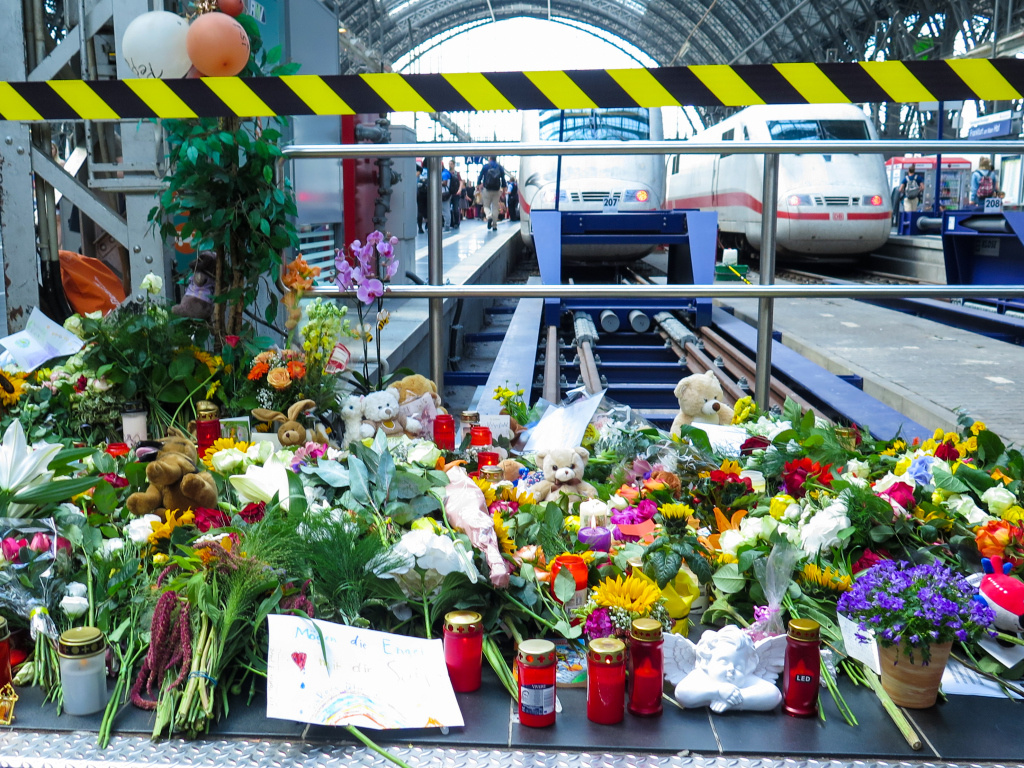 Blumen und Kerzen stehen vor dem Gleis am Frankfurter Hauptbahnhof. Menschen stellten sie für den achtjährigen Jungen auf, der vor den ICE gestoßen wurde und verstarb. (Foto: KNA)