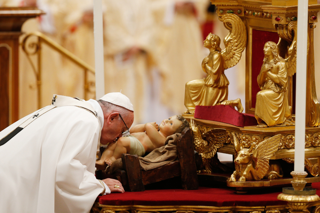 Papst Franziskus küsst eine Figur des Jesuskindes während der Christmette. (Foto: KNA)